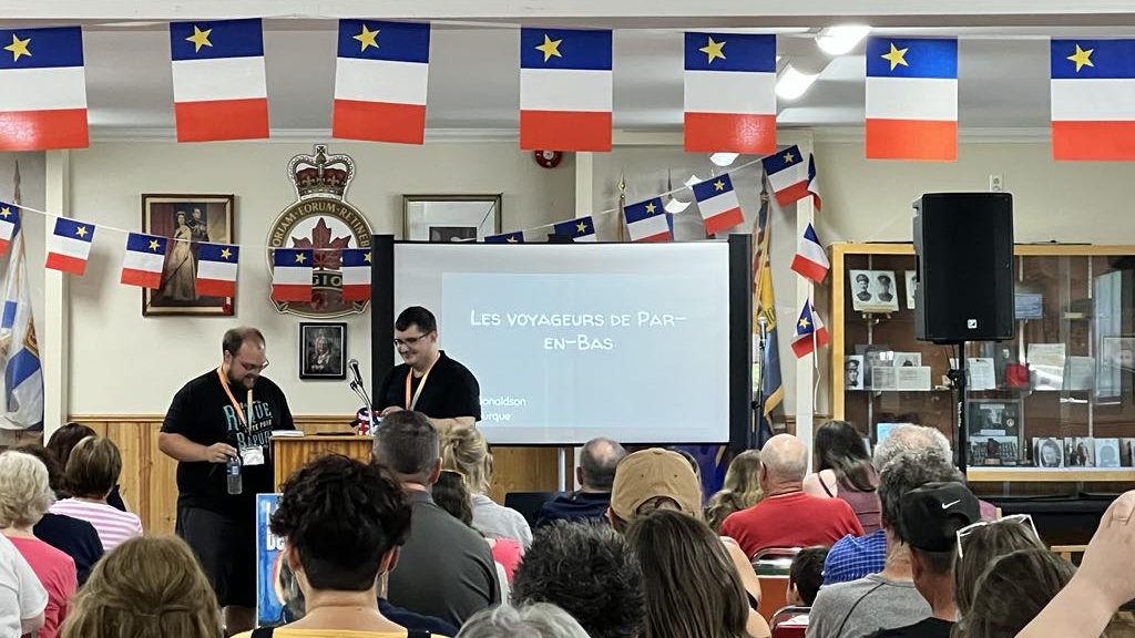 Plan moyen sur le public en train d'assister à la présentation du livre et de quelques extraits par les auteurs.