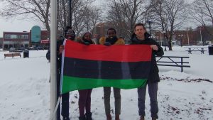 Le maire de Miramichi Adam Lordon et des représentantes de l'organisme Miramichi Afro Connection tiennent un drapeau pan-africain.