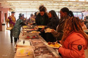 Des personnes se servent dans un buffet de nourritures africaines dans la cafétéria du Carrefour communautaire Beausoleil.