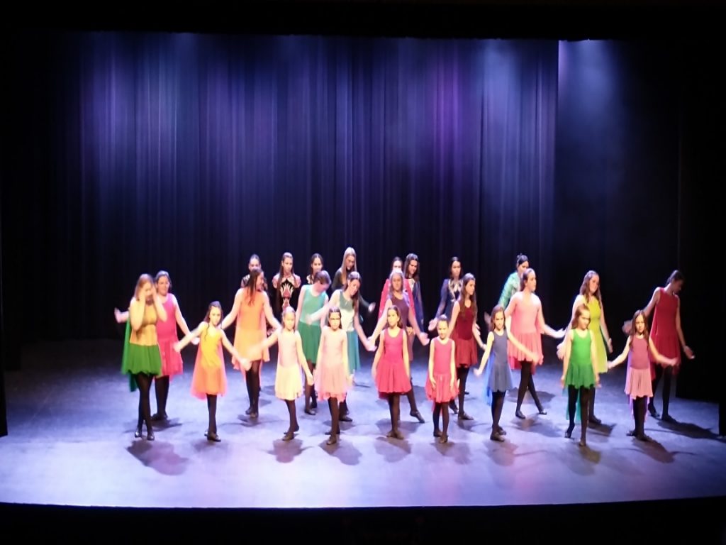 Un groupe de jeunes interprète un numéro de danse sur scène.