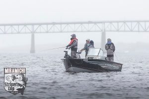 Photographie d'un petit bateau de pêche sur la rivière Miramichi, dans la brumante.