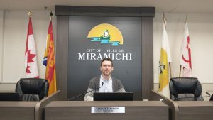 Le maire de Miramichi Adam Lordon est assis à sa place dans la salle du conseil municipal.