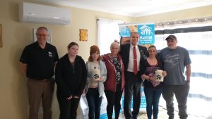 Photographie des deux familles récipiendaires d'un logement abordable en compagnie du directeur général d'Habitat pour l'humanité Nouveau Brunswick et le député Sam Johnston.