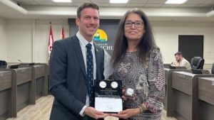 Photographie du maire Adam Lordon, qui remet une plaque commémorative à l'artiste Pauline Young.