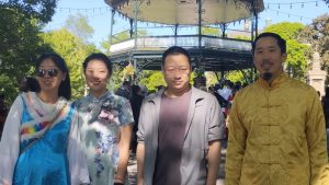 4 personnes d'origine chinoise posent. Elles portent des habits traditionnels colorés