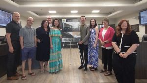 Photographie de Judy Losier, entournée de membres de sa famille et de membres du conseil municipal, dans la salle du conseil municipal de Miramichi.