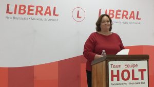 Photographie de Hannah Fulton Johnston devant un lutrin aux couleurs du parti Libéral du Nouveau-Brunswick.