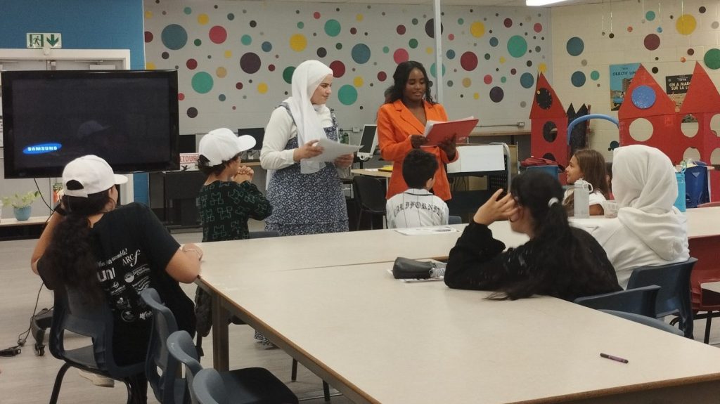 Les animatrices remettent un diplome de fin de club de lecture aux jeunes