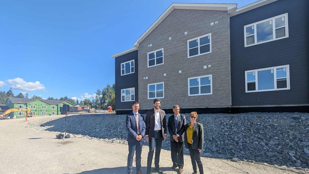 Les hommes et femmes politique du secteurs posent devant l'une des unité en construction