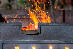 Plan rapproché d'un barbecue duquel jaillissent des flammes.