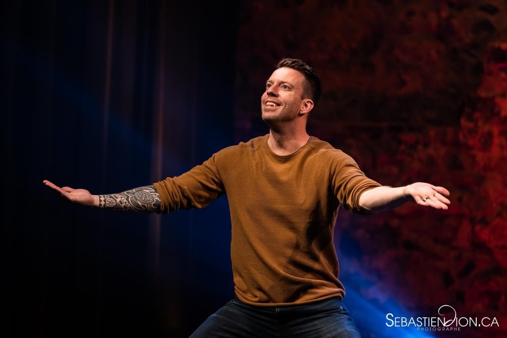 Photographie de l'humoriste Alex Roy en plein spectacle.