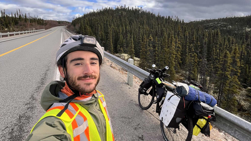 Égoportrait de Donnie Edery devant un panorama de Terre-Neuve-et-Labrador