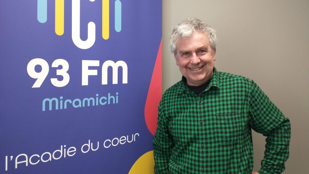 Photographie de Jean Dallaporta aux côtés du logo de C93.