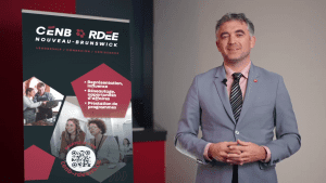 Photographie de Jonathan Duffaud aux côtés d'une bannière arborant l'image de marque commune du Conseil économique du Nouveau-Brunswick et du Réseau du développement économique et de l'employabilité du Nouveau-Brunswick.