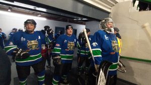 Photographie des joueurs de l'équipe des Villageois avant de monter sur la glace avant leur match qui les oppose aux Anciens Canadiens.