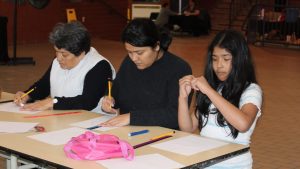 Photographie montrant une famille lors d'un atelier de dessin.