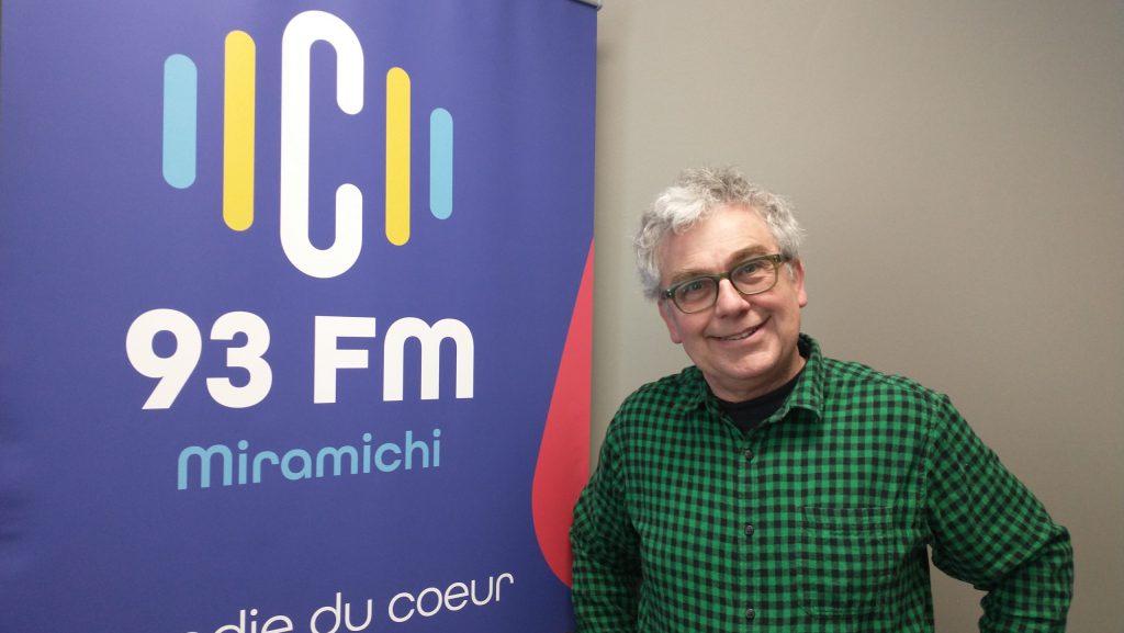 Photographie de Jean Dallaporta aux côtés du logo de C93.