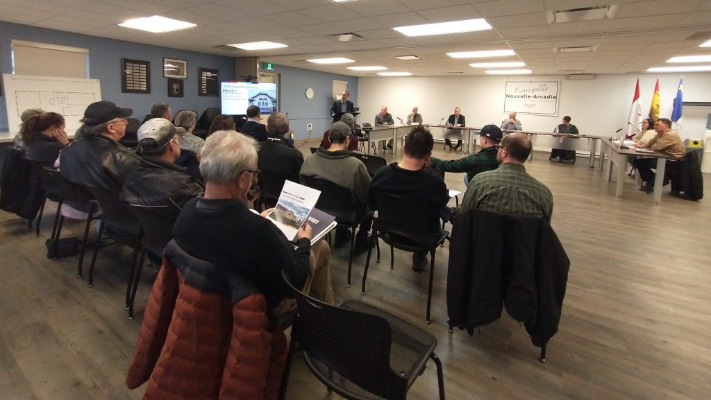 Photographie de la salle communautaire de l'édifice municipal de Nouvelle-Arcadie, où se tient une séance du conseil municipal.