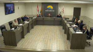 Photographie de la salle où siège le conseil municipal de Miramichi, en pleine séance.