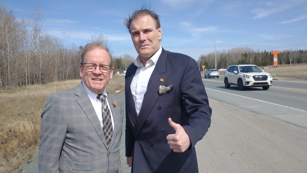 Photographie du ministre des Transports Chuck Chiasson et du député Sam Johnston, qui lève le pouce.
