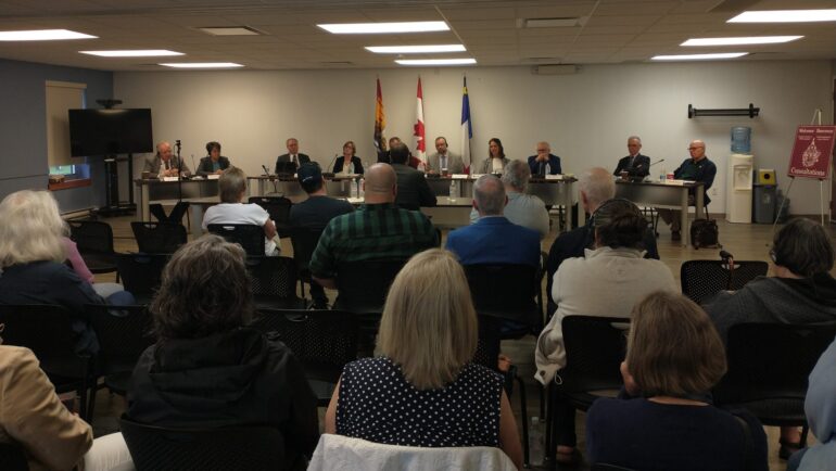 Photographie de la salle communautaire de l'édifice municipal de Nouvelle-Arcadie, aménagée en salle d'audience.