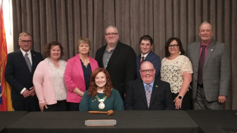 Photographie du conseil municipal de Miramichi, réuni derrière la mairesse Véronique Arsenault.