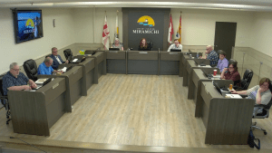 Photographie de la salle du conseil municipal de Miramichi, où la conseillère Peggy Doyle est absente.