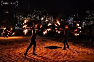 Photographie du trio Geomatrix en pleine prestation, avec divers équipements enflammés.