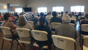 Photographie montrant une salle comble siégeant devant le Conseil municipal de Miramichi.