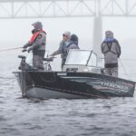 Photographie d'un petit bateau de pêche sur la rivière Miramichi, dans la brumante.