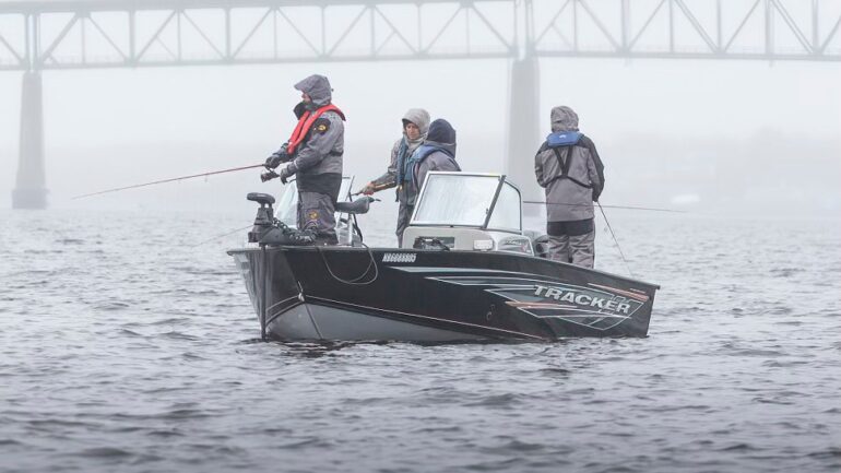 Photographie d'un petit bateau de pêche sur la rivière Miramichi, dans la brumante.