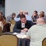 Plan rapproché de tables où des gens mènent des conversations.